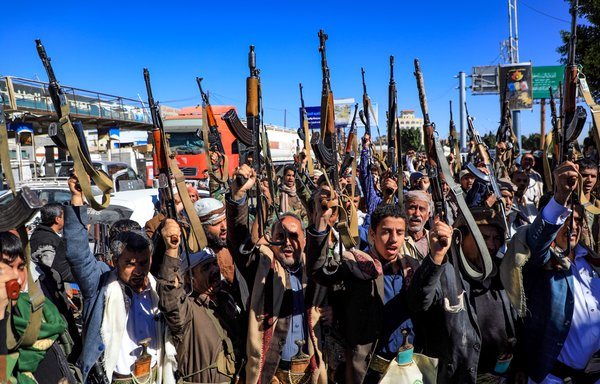 In this photo taken on January 27, armed Yemeni supporters of the Iran-backed Houthis brandish their weapons at a rally in Sanaa. [Mohammed Huwais/AFP]