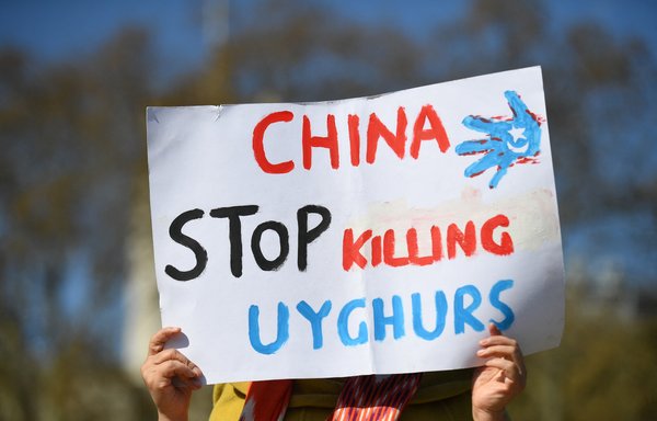 A member of the Uighur community last April 22 in London holds a placard as she joins a demonstration to call on the British parliament to vote to recognise Chinese persecution of Muslim minority Uighurs as genocide and crimes against humanity. [Justin Tallis/AFP]