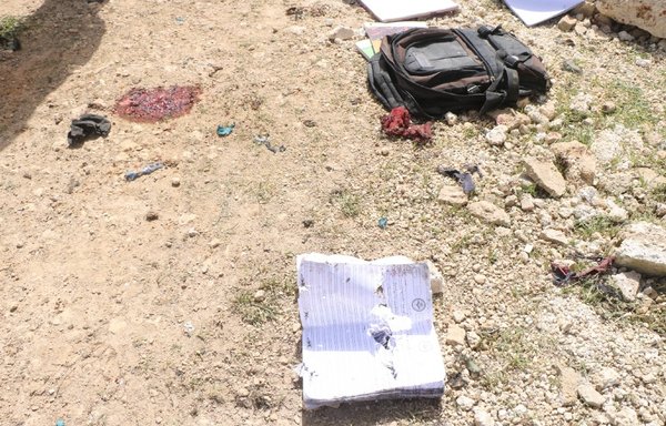 A school notebook and a book bag litter the area where Syrian children were hit by regime or Russian artillery fire on April 4 on their way home from school in Idlib province. [White Helmets]