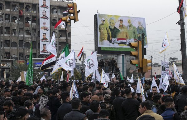 Members and supporters of Iraq's Popular Mobilisation Forces take part in a symbolic funeral for top Iranian commander Qassem Soleimani and paramilitary chief Abu Mahdi al-Muhandis in Baghdad on January 1, two days before the second anniversary of their death. [Sabah Arar/AFP]