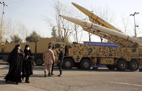 Iranian women walk next to Zolfaghar-Basir and Dezful missiles displayed at the Mosallah mosque in Tehran on January 7. [AFP]