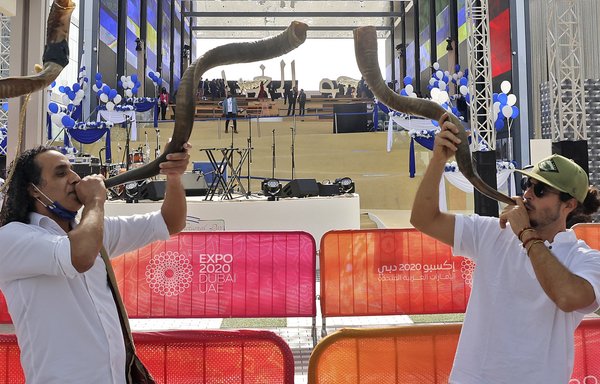 Men blow shofars (traditional Jewish religious instrument made from rams' horns) during Israel's Expo 2020 Dubai National Day in the gulf emirate on January 31. [Karim Sahib/AFP]