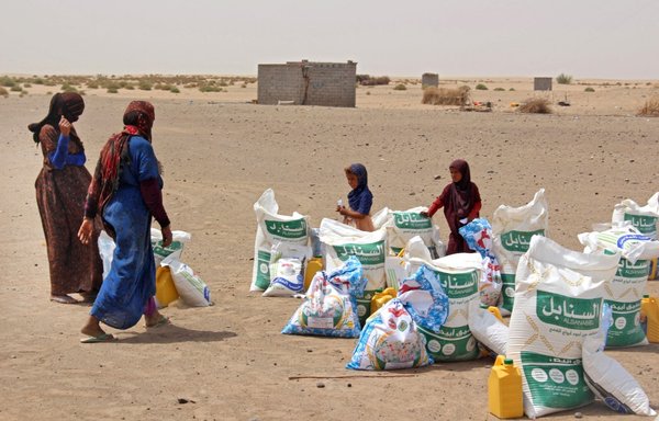 أسر تتلقى حصصا من الدقيق وغيره من إمدادات الأغذية الأساسية من جمعيات خيرية في محافظة لحج اليمنية يوم 29 آذار/مارس. تضاعفت أسعار الأغذية منذ العام الماضي، وثمة مخاوف من حدوث مجاعة شديدة نظرا لأن أوكرانيا تورد نحو ثلث واردات اليمن من القمح. [صالح العبيدي/وكالة الصحافة الفرنسية]