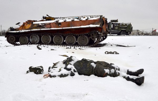 The body of a Russian soldier lies near destroyed military vehicles on the outskirts of Kharkiv on February 26. [Sergey Bobok/AFP]
