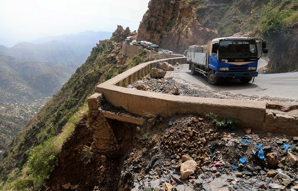 Vehicles drive along a heavily damaged road, the only travel route between Taez and Aden, on September 23, 2020. Yemen's new leadership has initiated negotiations to open the road, which is controlled by the Houthis. [Ahmad al-Basha/AFP]