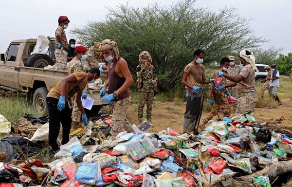Yemeni forces prepare to incinerate packages of alleged narcotics seized from across various areas in Yemen's northern Hajjah province near the border with Saudi Arabia on October 5. [Mohammed al-Wafi/AFP]