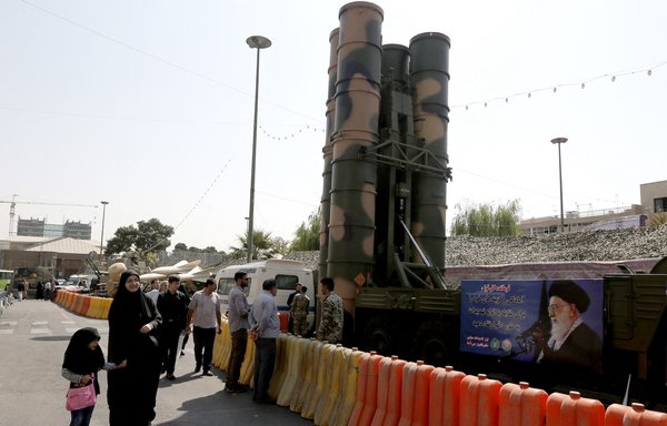 People walk past a Russian-made S-300 air defence system displayed in Tehran on September 25, 2017, during the annual defence week, which commemorates the 1980s Iran-Iraq war. [Atta Kenare/AFP]