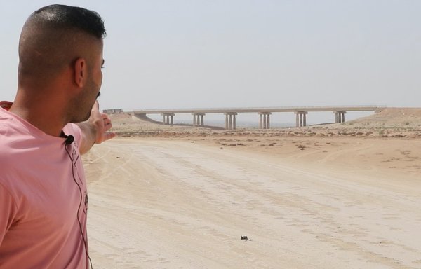 A man points to the dry bed of Lake Hamreen, which used to supply Iraq's Diyala province with more than 70% of its drinking and irrigation water, on May 15. [The Taafi Initiative]