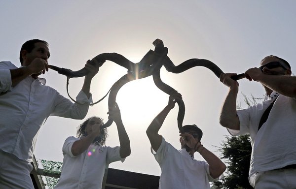 Men blow shofars (traditional Jewish musical instruments) during Israel's Expo 2020 Dubai National Day in the gulf emirate on January 31. [Karim Sahib/AFP]