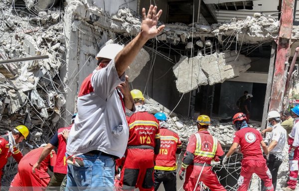 عمال الإنقاذ يحاولون إبعاد الناس من موقع المبنى خلال بحثهم عن الجثث تحت الركام في مجمع متروبول بعبادان يوم 30 أيار/مايو. [وكالة إسنا]