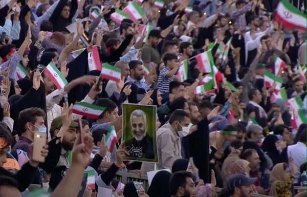 أثناء احتفال غنائي في مجمع أزادي الرياضي بطهران في أواخر شهر أيار/مايو بعد إصدار أغنية جديدة مؤيدة لخامنئي بعنوان "تحية أيها القائد!"، حمل عدة أشخاص صورا للقائد السابق لفيلق القدس التابع للحرس الثوري الإيراني قاسم سليماني المذكور في الأغنية. [لقطة شاشة من IRIB]