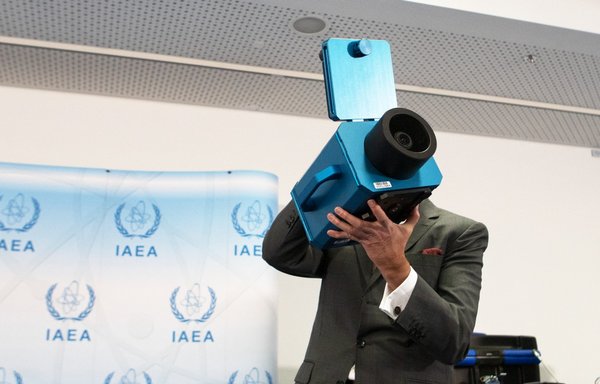 در روز ٢٦ آذرماه سال گذشته، رافائل گروسی، مدیرکل آژانس بین‌المللی انرژی اتمی، یک دوربین نظارتی را در مقر آژانس در وین، اتریش، نشان می‌دهد. [الکس هالادا/خبرگزاری فرانسه]