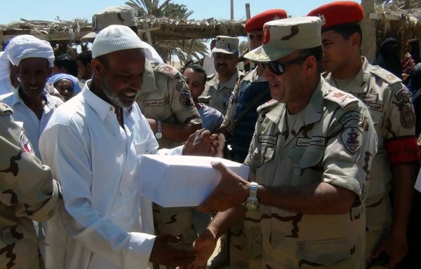 An Egyptian army officer presents a gift to a Sinai tribesman in this file photo from September 7, 2015. [Official page of the Egyptian Armed Forces spokesman]