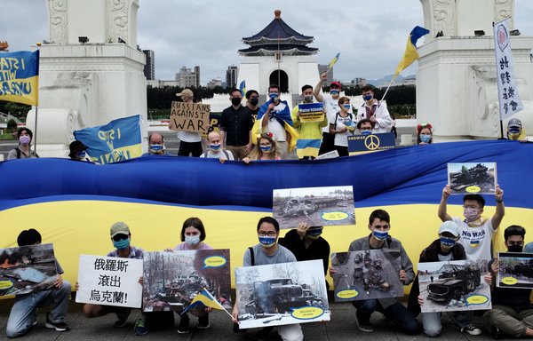 Slavs and other residents of Taiwan display posters and a Ukraine flag during a rally in Taipei on May 8. [Sam Yeh/AFP]