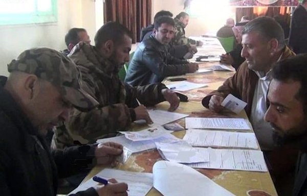 Syrian men fill out paperwork to reconcile their status with the regime. The number of reconciliations has increased recently, sources say, because of fears of losing Russian protection. [SANA News Agency]