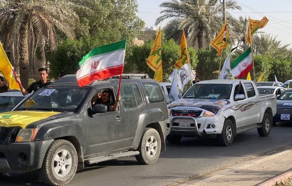 عناصر من ميليشيات عراقية تدعمها إيران يرفعون الأعلام الإيرانية خلال استعراض أقيم يوم 11 حزيران/يونيو الجاري في شوارع بغداد. [صورة متداولة على الإنترنت]