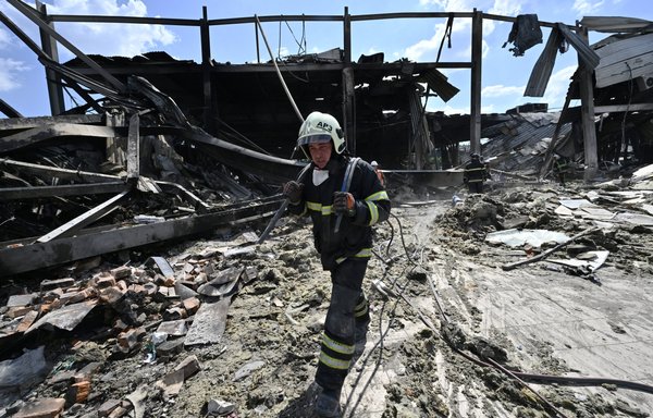A rescuer clears rubble at the Amstor mall in Kremenchuk, Ukraine, on June 28, one day after it was hit by a Russian missile strike. [Genya Savilov/AFP]