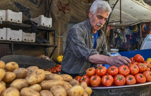 A produce vendor arranges vegetables for sale on a Damascus market stall on April 14, 2021. [SANA]