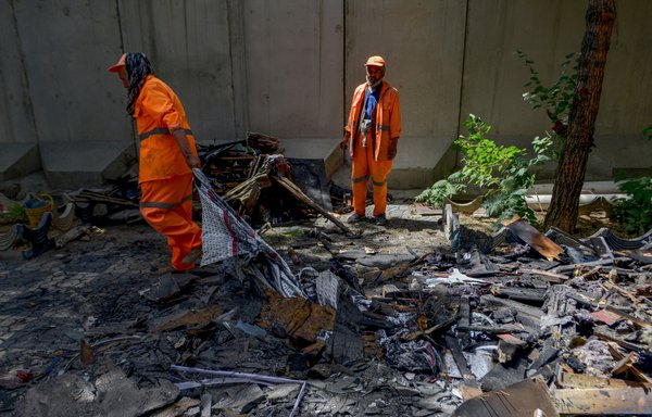 Afghan municipal workers clean up the debris from inside a compound of a Sikh temple in Kabul on June 20, a few days after an attack claimed by ISIS. [Ahmad Sahel Arman/AFP]