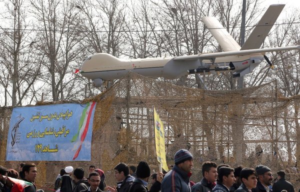 Iranians walk past Iran's Shahed 129 drone during celebrations in Tehran to mark the anniversary of the Islamic revolution on February 11, 2016. [Atta Kenare/AFP]