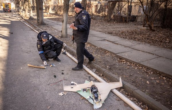Ukrainian police officers inspect a downed Russian drone after a strike in northwestern Kyiv on March 22. [Fadel Senna/AFP]