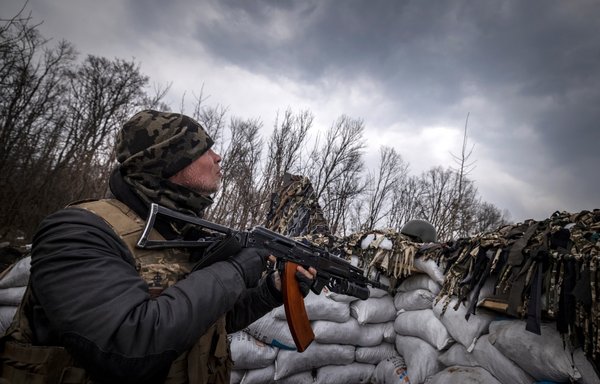 A Ukrainian serviceman holding an assault rifle looks at a Russian drone in a trench at the front line east of Kharkiv, on March 31. [Fadel Senna/AFP]