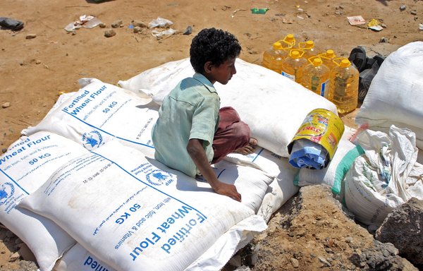 Displaced Yemenis receive humanitarian aid provided by the World Food Programme in Yemen's northern province of Hajjah on June 6. [Essa Ahmed/AFP]