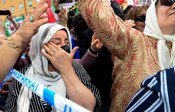 People react outside Stockholm District Court in Sweden on July 14, after the life sentence in the war crime trial of Hamid Noury was spoken. [Chris Anderson/TT News Agency/AFP]