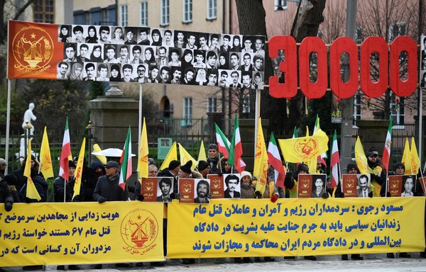 In this file photo taken November 23, people demonstrate outside the Stockholm District Court in connection with the war crime trial of Iranian national Hamid Noury. [Duygu Getiren/TT News Agency/AFP]