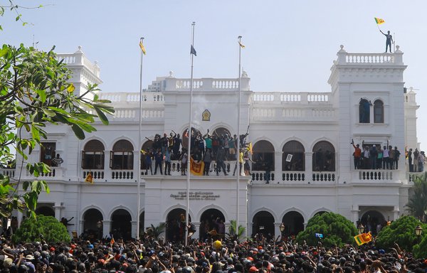 Thousands of anti-government protesters stormed into Sri Lankan Prime Minister Ranil Wickremesinghe's office on July 13, hours after he was named as acting president. [AFP]