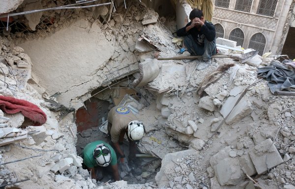 Members of the White Helmets search for victims amid the rubble of destroyed buildings following a Syrian regime air strike on the opposition-held Aleppo neighbourhood of Bustan al-Basha on October 4, 2016. Russia was accused of bombing indiscriminately during the Aleppo campaign, including targeting its hospitals. [Thaer Mohammed/AFP]