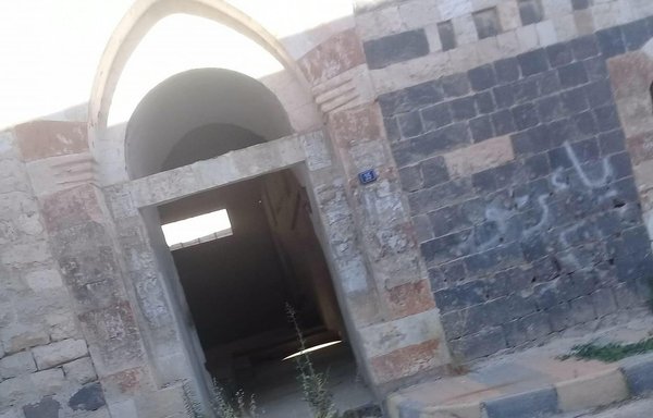 A bullet-scarred archway in the Syrian town of al-Qusayr shows the lingering legacy of battles with Hizbullah. [Hadi al-Abdullah]