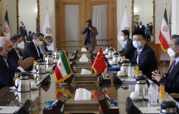 Then-Iranian Foreign Minister Javad Zarif (left) meets with his Chinese counterpart Wang Yi (right) in Tehran on March 27, 2021, to sign what state television called a '25-year strategic co-operation pact'. [AFP]