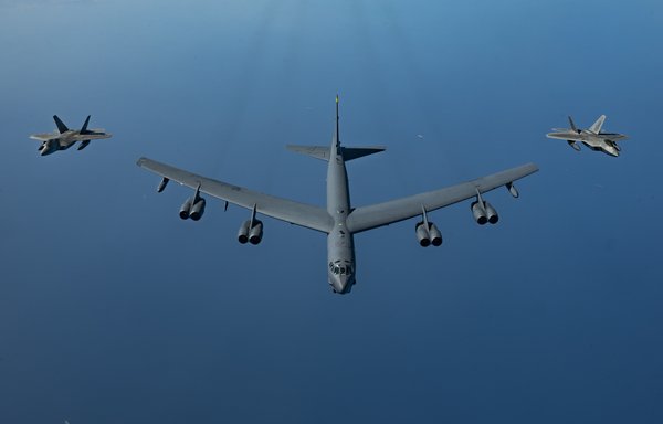 US Air Force F-22 Raptors fly alongside a US Air Force B-52 above the Arabian Gulf on March 29. [US Air Force]