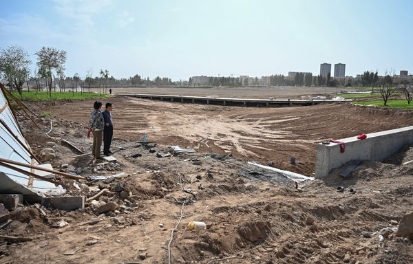 This photo taken in 2019 shows park construction under way on the former site of a Uighur cemetery in Kuche, Xinjiang region, China. China has destroyed burial grounds where generations of Uighur families have been laid to rest, leaving behind human bones and broken tombs in what activists call an effort to eradicate the ethnic group's identity in Xinjiang. [Hector Retamal/AFP]