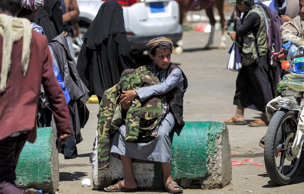 A boy sells jackets to pedestrians in Houthi-controlled Sanaa on March 24. [Mohammed Huwais/AFP]