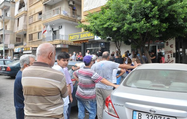A youth outside a currency exchange in Beirut waits for money. [Ziad Hatem/Al-Mashareq]
