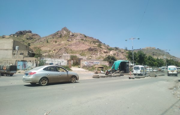 Vehicles pass through a Houthi checkpoint at the entrance of Bayt Baws district, south of Sanaa. [Haitham Mohammed/Al-Mashareq]