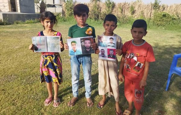 روز ۹ شهریور، کودکان تصاویری از پدران مفقود‌شدۀ خود را که گمان می‌رود با اعمال زور به‌وسیلۀ شبه‌نظامیان ناپدید شده‌ باشند، در دست دارند. [حساب توییتر وائل الطائی]