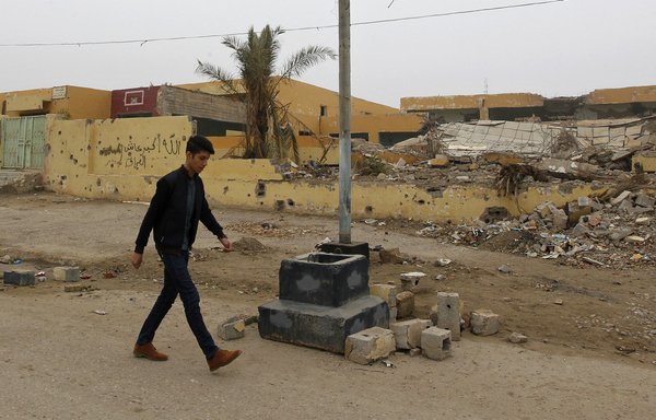 یک جوان عراقی در آذر ۱۳۹۵، تقریباً شش ماه پس از بازپس‌گیری شهر فلوجه از داعش، در امتداد خیابانی آسیب‌دیده در این شهر قدم می‌زند. [صباح عرار/ خبرگزاری فرانسه]