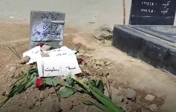 Mahsa Amini's burial site (left) is shown in Saghez on September 17, with a Kurdish sign that reads 'You haven't died; your name will become a symbol.' [Joni.ir]