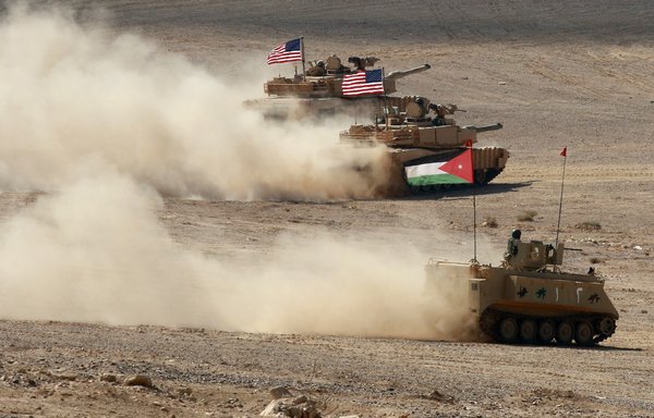 A Jordanian armoured personnel carrier and US tanks take part in the 'Eager Lion' multinational military exercise in the al-Zarqa governorate of Jordan on September 14. [Khalil Mazraawi/AFP]