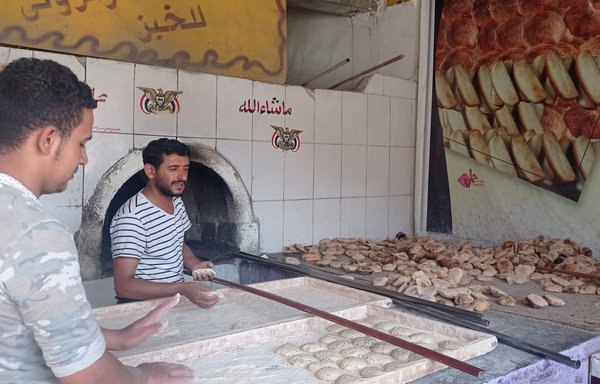 خبازون يجهزون أرغفة لإدخالها إلى الفرن في مخبز السنابل بحي الأصبحي في صنعاء في أيلول/سبتمبر الجاري. أدى ارتفاع سعر القمح بسبب الغزو الروسي لأوكرانيا إلى ارتفاع سعر الخبز في اليمن. [مخبز السنابل]