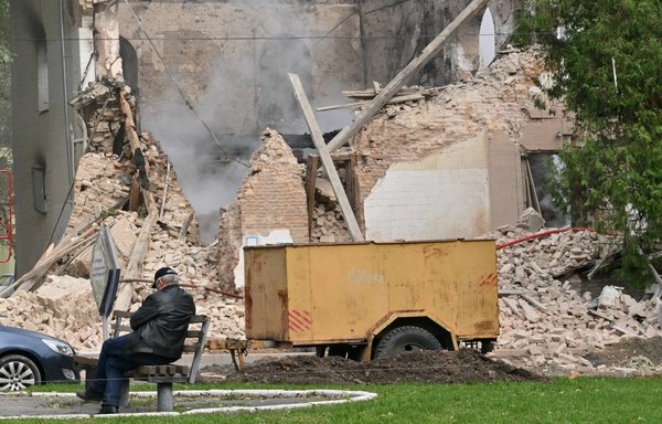 A local resident sits outside a building destroyed by Iranian-made drones deployed by Russia after an airstrike on Bila Tserkva, southwest of Kyiv, on October 5, amid the Russian invasion of Ukraine. [Sergei Supinsky/AFP]