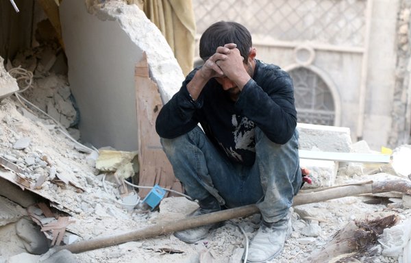A Syrian man sits on the rubble of destroyed buildings following a Syrian regime air strike on the Bustan al-Basha neighbourhood in Aleppo on October 4, 2016. Russia has been accused of bombing Aleppo indiscriminately, including targeting its hospitals. [Thaer Mohammed/AFP]