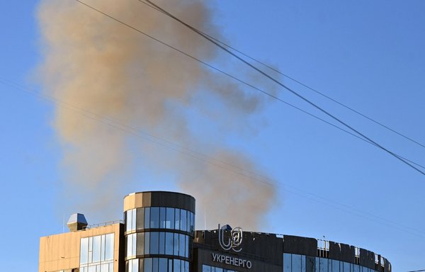 Smoke rises behind a building after a drone attack in Kyiv on October 17. Ukraine officials said an early morning Russian attack with Iranian drones damaged a residential building and targeted the central train station. [Sergei Supinsky/AFP]