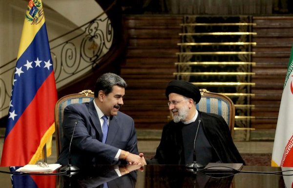 A handout picture provided by the Iranian presidency shows Iran's President Ebrahim Raisi (R) and Venezuela's President Nicolas Maduro (L) shaking hands during a joint statement after their meeting in the capital Tehran on June 11. [AFP]