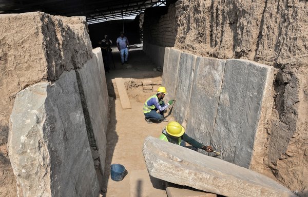 Iraqi workers excavate a rock-carving relief at the Mashki gate to the ancient Assyrian city of Ninawa, on October 19. [Zaid al-Obeidi/AFP]