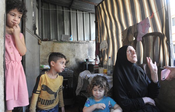 Kawkab Mahmoud Tarabishi and her grandchildren in their modest home in Bab al-Tabbaneh in Tripoli. [Ziad Hatem/Al-Mashareq]