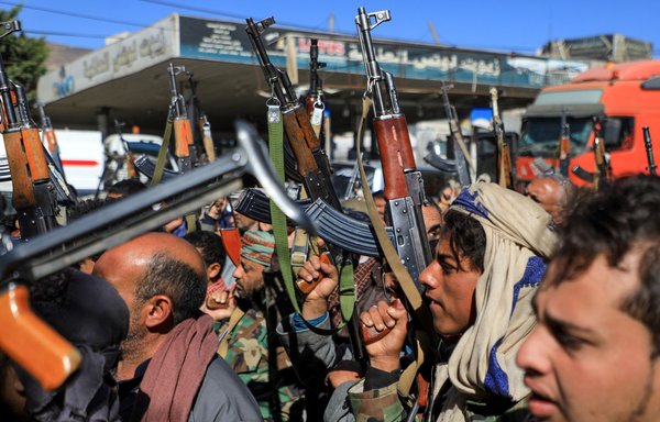 Armed Yemeni supporters of the Iran-backed Houthis brandish their weapons as they rally in Sanaa on January 27. [Mohammed Huwais/AFP]